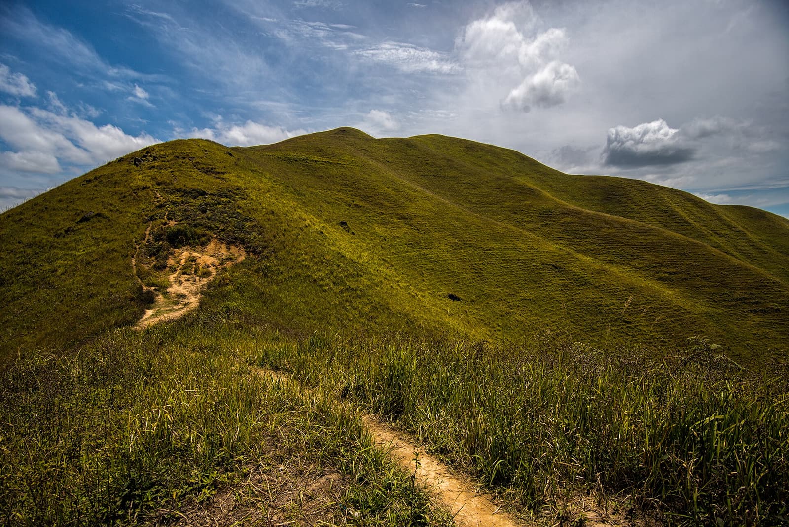 The grassy ridges of Bukit Holbung above the blue water of Lake Toba