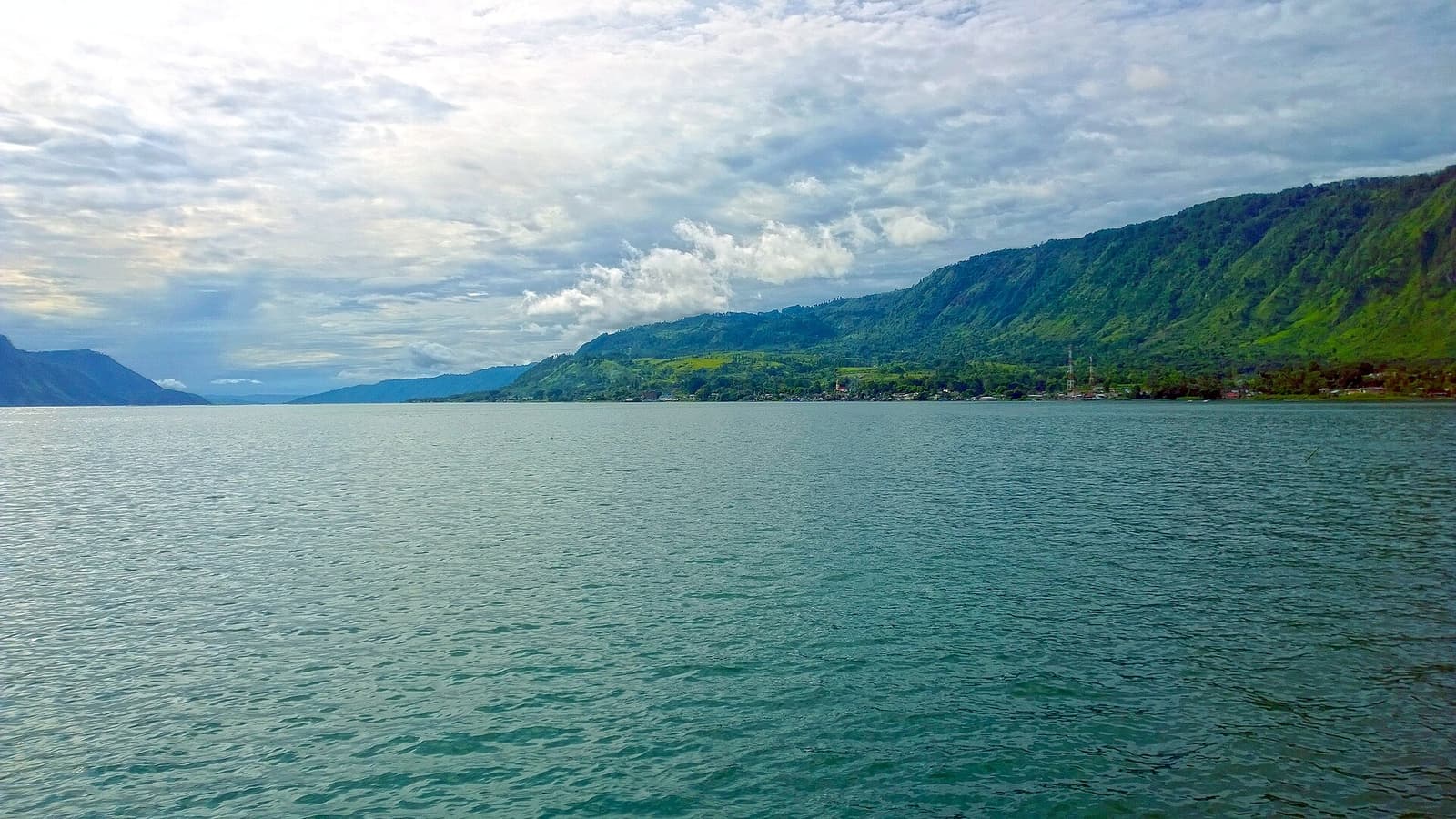 A wide view of Samosir Island across the water of Lake Toba