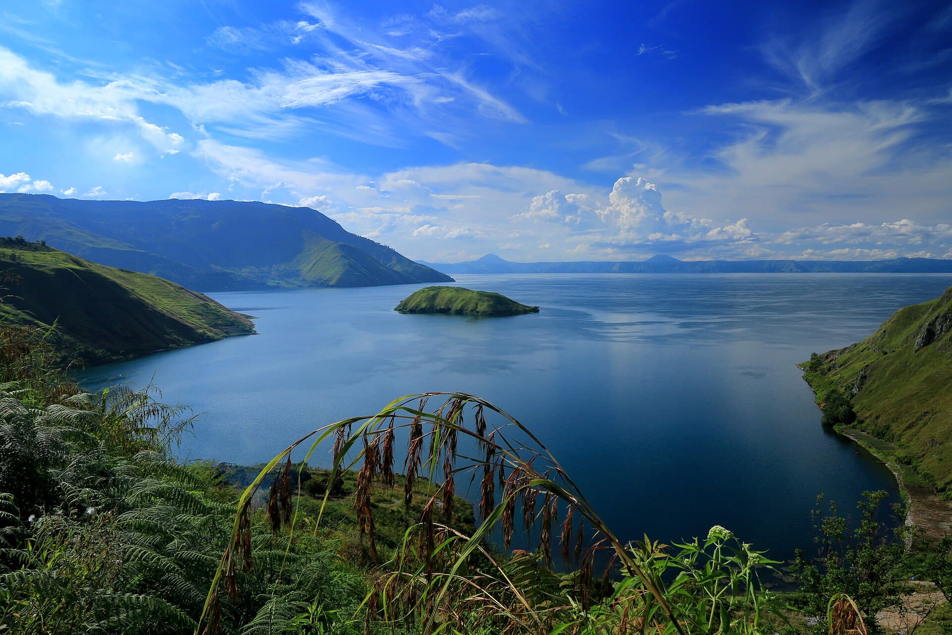 Lake Toba and its steep green shores under a blue sky, North Sumatra